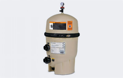 A Pentair Clean & Clear Plus pool filter system with a tan body and black pressure gauge on top. Warning labels and instructions are affixed to the upper part of the filter, with inlet and outlet ports on the lower side. The system is set against a white background.