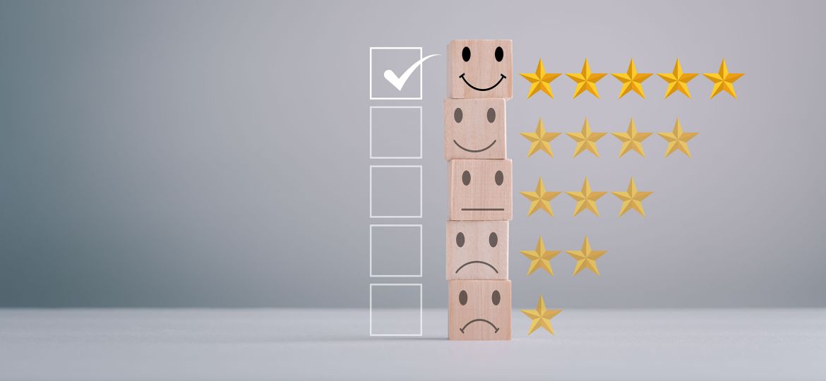 A stack of wooden blocks displaying different facial expressions, from top to bottom: a smiling face with five gold stars, a neutral face with four gold stars, a slightly sad face with three gold stars, and a very sad face with one gold star. To the left of the stack is a vertical row of empty checkboxes, with the topmost box checked. The image represents a rating or feedback system. This is symbolic of the Heliocol Solar Pool Heating System being the top choice for our customers.