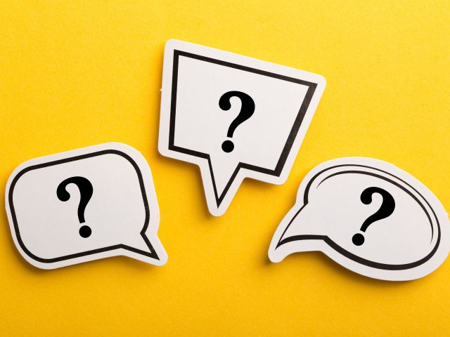 Three speech-bubble shapes with question marks on a bright yellow background
